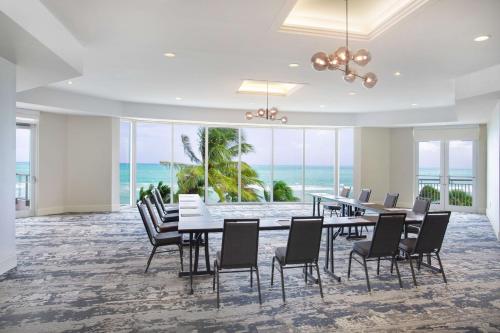 a dining room with a table and chairs and the ocean at DoubleTree by Hilton Ocean Point Resort - North Miami Beach in Miami Beach