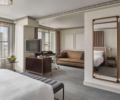 - une chambre d'hôtel avec un lit et un miroir dans l'établissement Hotel Phillips Kansas City, Curio Collection By Hilton, à Kansas City