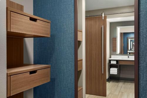 a bathroom with a sink and a mirror at Hilton Garden Inn Milwaukee Brookfield Conference Center in Brookfield