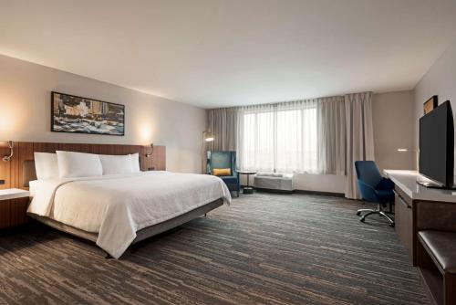 um quarto de hotel com uma cama e uma televisão em Hilton Garden Inn Milwaukee Brookfield Conference Center em Brookfield