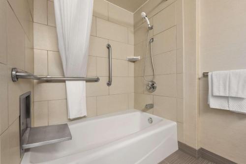 y baño con bañera blanca y toallas. en DoubleTree by Hilton Milwaukee/Brookfield en Brookfield