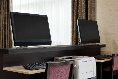 a desk with a computer monitor and a keyboard at DoubleTree by Hilton Milwaukee/Brookfield in Brookfield