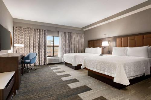 una camera d'albergo con 2 letti e una scrivania di Hampton Inn Suites Kansas City Downtown Crossroads a Kansas City