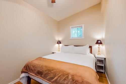 sypialnia z białym łóżkiem i 2 lampami w obiekcie Moose Point w mieście Cle Elum