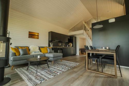 a living room with a couch and a table at Norlight Cottages Ivalo - Aurinko West in Ivalo