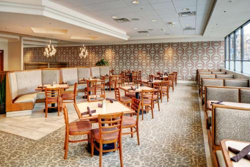 a dining room with wooden tables and chairs at DoubleTree by Hilton Milwaukee Downtown in Milwaukee