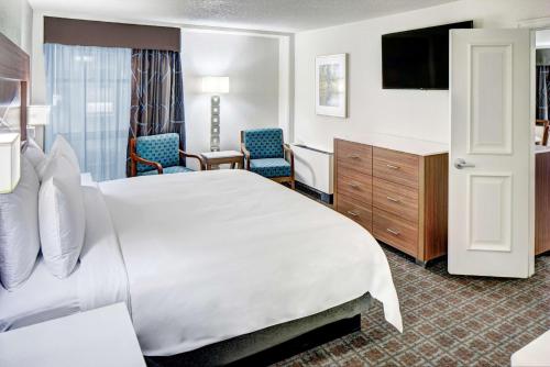 a hotel room with a large bed and chairs at DoubleTree by Hilton Milwaukee Downtown in Milwaukee
