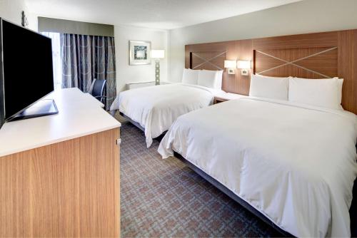 a hotel room with two beds and a flat screen tv at DoubleTree by Hilton Milwaukee Downtown in Milwaukee