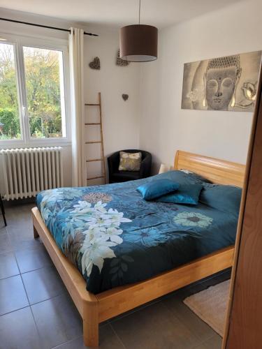 a bedroom with a bed with blue sheets and a window at Welcome in Nantes