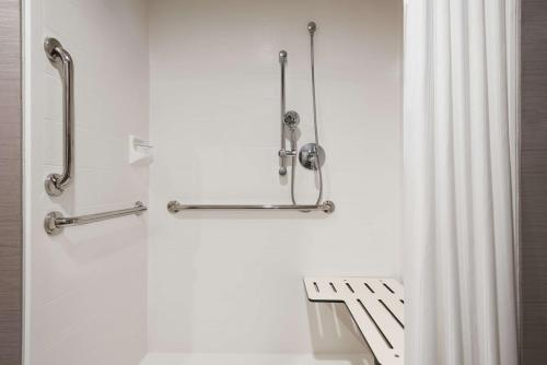 um chuveiro na casa de banho com uma cortina de chuveiro em Homewood Suites By Hilton Milwaukee Downtown em Milwaukee
