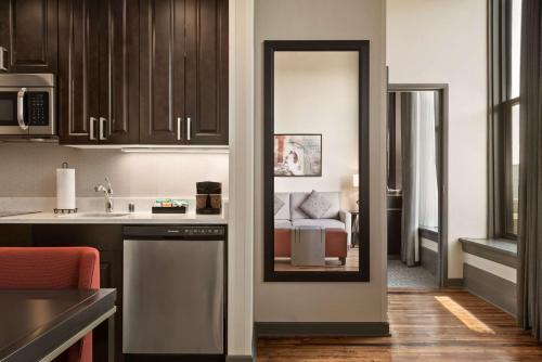 a kitchen with a sink and a room with a bed at Homewood Suites By Hilton Milwaukee Downtown in Milwaukee
