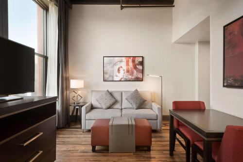 a living room with a couch and a table at Homewood Suites By Hilton Milwaukee Downtown in Milwaukee