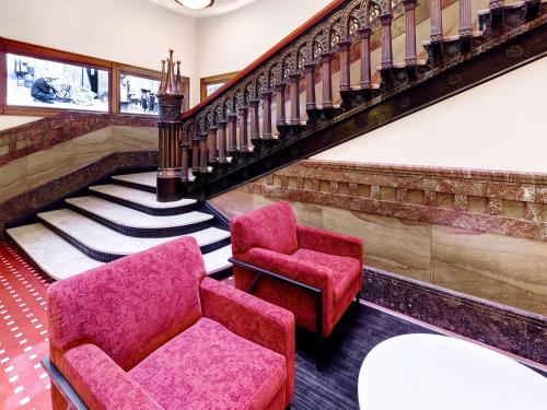 a living room with two chairs and a staircase at Hilton Garden Inn Milwaukee Downtown in Milwaukee