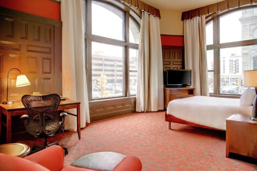 um quarto de hotel com uma cama, uma secretária e janelas em Hilton Garden Inn Milwaukee Downtown em Milwaukee