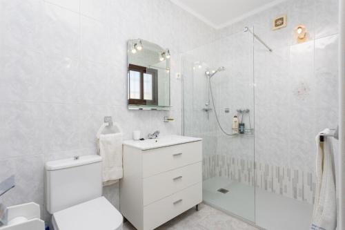 La salle de bains blanche est pourvue d'une douche, de toilettes et d'un lavabo. dans l'établissement Villa Alta Vista, à Frigiliana