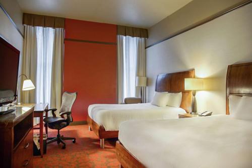 a hotel room with two beds and a desk at Hilton Garden Inn Milwaukee Downtown in Milwaukee