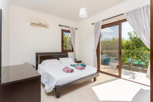 a bedroom with a bed and a sliding glass door at Villa Dora in Argaka