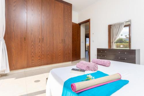 a bedroom with a bed with two towels on it at Villa Dora in Argaka