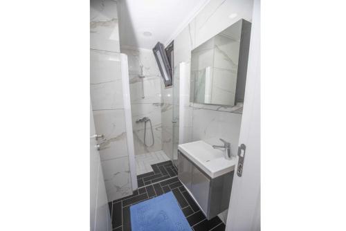 uma casa de banho branca com um lavatório e um chuveiro em Villa Welt em Dalyan