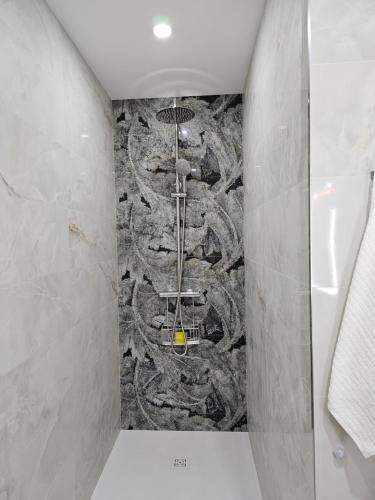 a bathroom with a shower with a stone wall at Lounge garden sea relax in Valencia