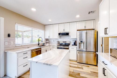 a kitchen with white cabinets and a stainless steel refrigerator at WeeCasa in Chandler