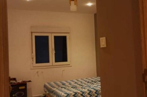1 dormitorio con cama y ventana en Desert-land apartment en El Bayadh
