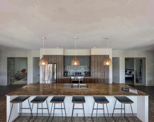 a kitchen with a large island with bar stools at Iro Luxury Retreat in Rarotonga