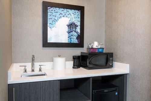 a bathroom counter with a sink and a microwave at Hampton Inn Midland in Midland