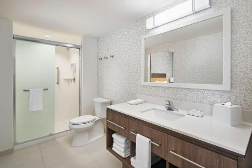 La salle de bains est pourvue d'un lavabo, de toilettes et d'un miroir. dans l'établissement Home2 Suites By Hilton Palm Bay I 95, à Melbourne