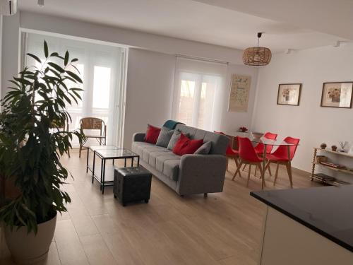 a living room with a couch and a table with red pillows at Precioso apartamento con patio in Granada