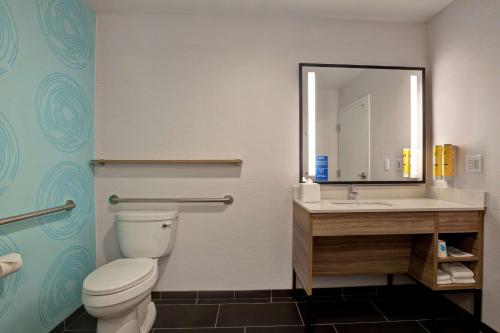 a bathroom with a toilet and a sink and a mirror at Tru By Hilton Manassas, Va in Manassas