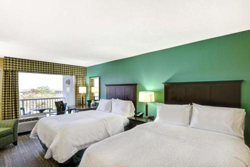 a hotel room with two beds and a green wall at Hampton Inn Mobile/East Bay in Daphne
