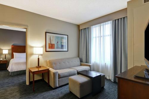a hotel room with a couch and a bed at Homewood Suites Mobile East Bay/Daphne in Daphne