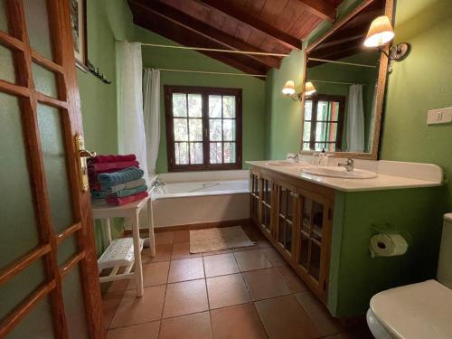 baño verde con bañera y lavamanos en La Casa del Molino de Viento en Agaete