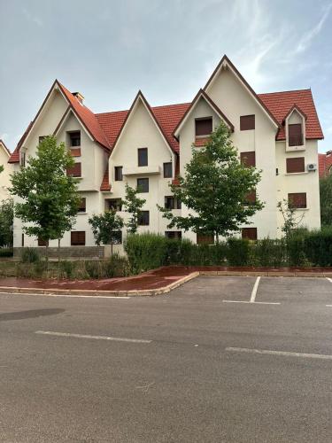 un gran edificio blanco con árboles frente a un aparcamiento en Ifrane apartment with swimming pool, en Ifrane