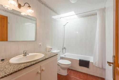 a bathroom with a sink and a toilet and a shower at Villa Gelabert Ametller in Cala en Bosc