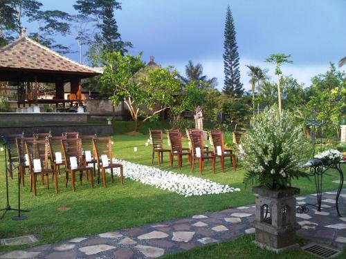 a row of chairs sitting in a field with white flowers at Bagus Jati Health & Wellbeing Retreat in Tegalalang