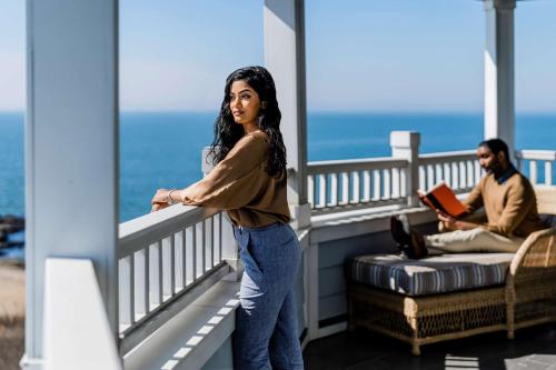 a woman standing on the balcony of a house at Madison Beach Hotel, Curio Collection by Hilton in Madison