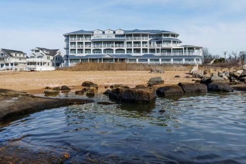 a large building on the beach with a body of water at Madison Beach Hotel, Curio Collection by Hilton in Madison