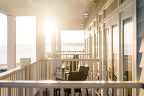 a balcony with chairs and a view of the ocean at Madison Beach Hotel, Curio Collection by Hilton in Madison