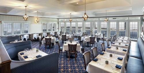 a restaurant with tables and chairs in a room at Madison Beach Hotel, Curio Collection by Hilton in Madison