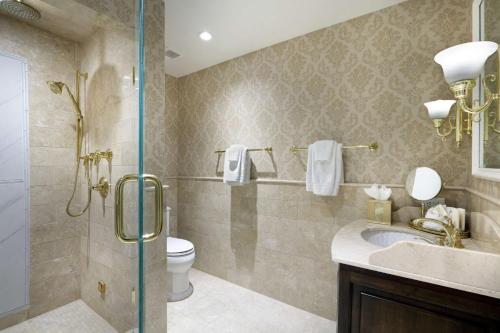 a bathroom with a sink and a toilet and a shower at Madison Beach Hotel, Curio Collection by Hilton in Madison