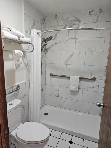 トゥクムカリにあるRodeway Innのバスルーム(白いトイレ、シャワー付)