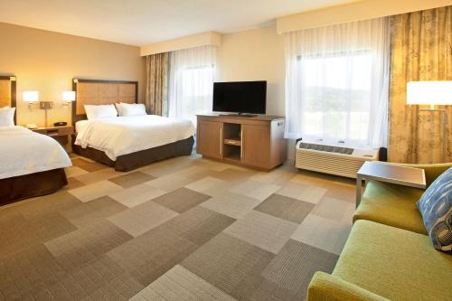 a hotel room with two beds and a flat screen tv at Hampton Inn & Suites Nashville-Smyrna in Smyrna