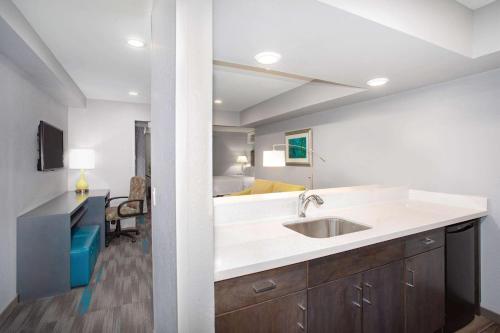 a kitchen with a sink and a living room at Hampton Inn Monterey in Monterey