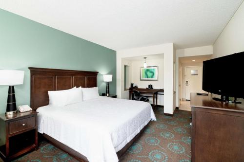a hotel room with a bed and a flat screen tv at Hampton Inn & Suites Mooresville in Mooresville