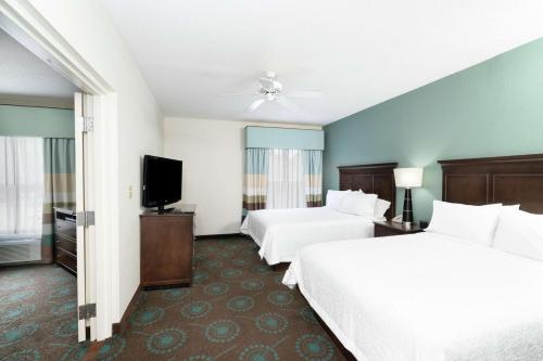 a hotel room with two beds and a flat screen tv at Hampton Inn & Suites Mooresville in Mooresville