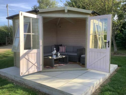 an open door of a shed with a couch at The Retreat, Clematis cottages, Stamford in Stamford