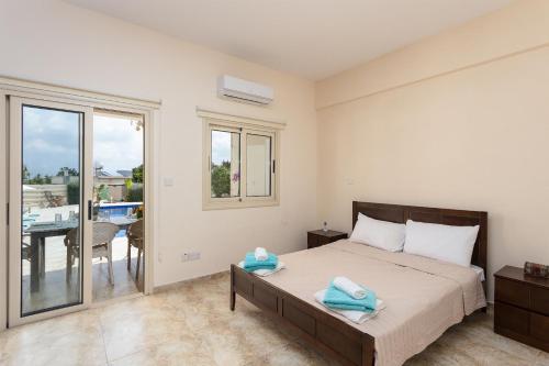 a bedroom with a bed and a balcony at Villa Elite in Droushia