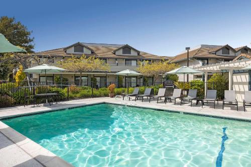 uma grande piscina com cadeiras e guarda-sóis em Seacliff Inn Aptos, Tapestry Collection by Hilton em Aptos